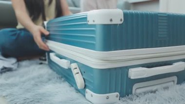 Kadın bavulunu evdeki seyahat çantasına yerleştiriyor.