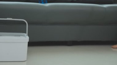 Adam elektrikli süpürgeyle temizlik yapıyor..