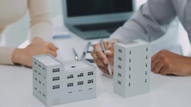 Emlakçı ve ev modeli ofiste