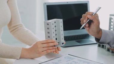 Hesap makinesini tutan ve iş planını gösteren genç iş adamına yakın plan.