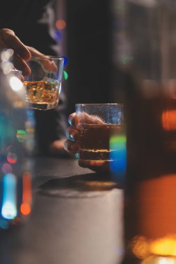 Kutlama gecesi, bardağa viski dök. Kutlamaya gelen arkadaşlarına ver.