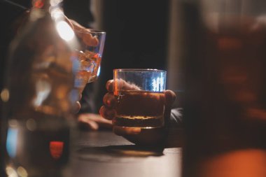 Kutlama gecesi, bardağa viski dök. Kutlamaya gelen arkadaşlarına ver.