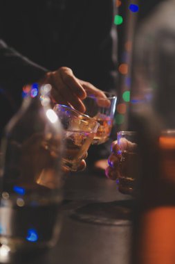 Kutlama gecesi, bardağa viski dök. Kutlamaya gelen arkadaşlarına ver.