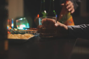 Kutlama gecesi, bardağa viski dök. Kutlamaya gelen arkadaşlarına ver.