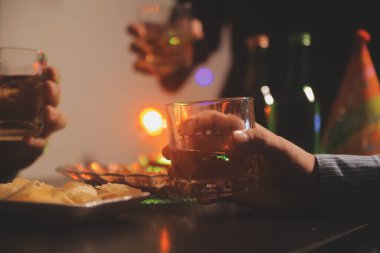 Kutlama gecesi, bardağa viski dök. Kutlamaya gelen arkadaşlarına ver.