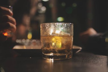 Kutlama gecesi, bardağa viski dök. Kutlamaya gelen arkadaşlarına ver.