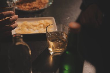 Kutlama gecesi, bardağa viski dök. Kutlamaya gelen arkadaşlarına ver.