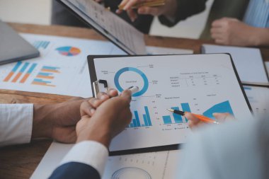 Co çalışma konferans, dizüstü bilgisayar ve dijital tablet, Ofis Masaları üzerinde yeni planı mali grafik verilerini tartışırken yatırımcı meslektaşları mevcut, Toplantı iş takım finans, muhasebe, yatırım.