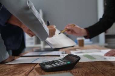 İş ekibi toplantısı yeni bir başlangıç projesi üzerinde çalışıyor, verileri tartışıyor ve analiz ediyor çizelgeler ve grafikler. Dijital tablet, hesap makinesi, dizüstü bilgisayar kullanımı, iş finans ve muhasebe kavramı.