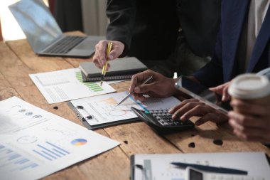 İş ekibi toplantısı yeni bir başlangıç projesi üzerinde çalışıyor, verileri tartışıyor ve analiz ediyor çizelgeler ve grafikler. Dijital tablet, hesap makinesi, dizüstü bilgisayar kullanımı, iş finans ve muhasebe kavramı.