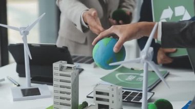 Ofis masasında modelli dünyayı tutan iş adamları.