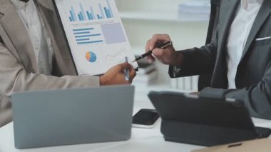 İş adamlarının iş grafiklerini ve grafiklerini tartışırken yakın plan