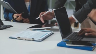 Ekonomik çizelgeler ve dizüstü bilgisayarla iş ekibi ofisinde çalışıyor..