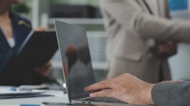 Yakın plan - bir iş adamının bilgisayarını kullanarak arka planda bir şeyi tartışırken görüntüsü