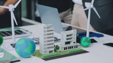 Modeli, modeli olan bir iş adamının minyatürü. Rüzgâr, sürdürülebilir bir modelin yeşil modelini tutuyor.,