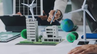 Minyatür insanlar ve iş adamları bir güneş enerjisi istasyonu modeli üzerinde çalışıyorlar.