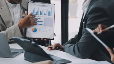 Dizüstü bilgisayardaki yatırım verilerini analiz eden işadamı ve çoklu veri içerisindeki hesap makinesi