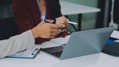 İş adamları modern bir ofiste tartışıyor ve çalışıyorlar.