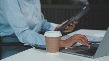 Genç adam ofiste dizüstü bilgisayar kullanıyor..