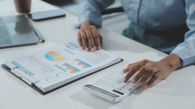 Ofiste dizüstü bilgisayar ve hesap makinesiyle çalışan işadamlarının kapatılması.