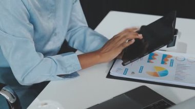 İşadamı dijital tablet kullanıyor ve masanın üzerinde bir çizelge var.