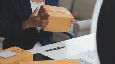 İş adamı elinde bir karton kutu tutuyor ve işe hazırlanmak için dizüstü bilgisayar kullanıyor..