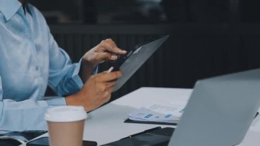 Ofiste tablet ve dizüstü bilgisayarla çalışan iş kadını