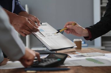 İş ekibi toplantısı yeni bir başlangıç projesi üzerinde çalışıyor, verileri tartışıyor ve analiz ediyor çizelgeler ve grafikler. Dijital tablet, hesap makinesi, dizüstü bilgisayar kullanımı, iş finans ve muhasebe kavramı.