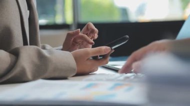 Ofiste bilgisayar ve akıllı telefon kullanan bir işadamı.