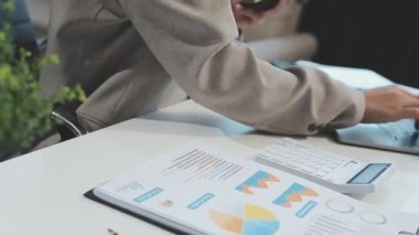 İş yerinde bilgisayar ve akıllı telefon kullanan bir iş kadını.