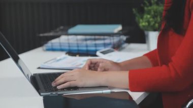 İşyerindeki ofiste dizüstü bilgisayar kullanan iş kadını.