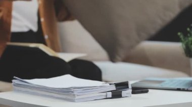 Kadın elleri masanın üstünde, evde çalışıyor.