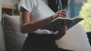 Evdeki not defterine yazan kadın.