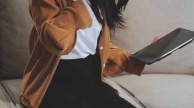 Oturma odasında Tablet kullanan Genç Kadın