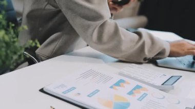 İş adamı, iş yerinde finansal tablet ve grafikler kullanan bir tablet bilgisayar kullanıyor.