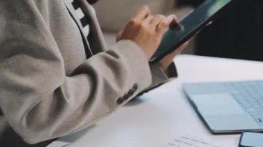 Genç iş adamı modern ofiste tablet bilgisayar kullanıyor.