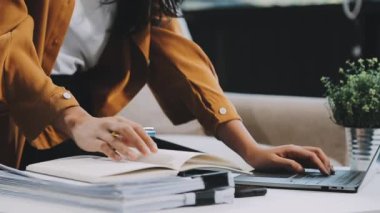 İş kadını bir deftere not yazıyor. Evden çalışmak.