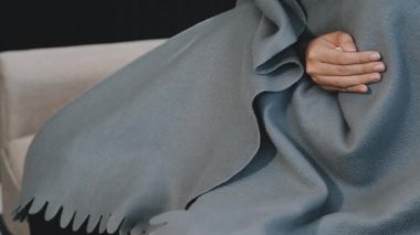 Kanepede beyaz kazak giyen kadın bacakları.