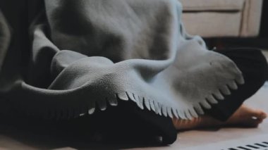 Kadın yatakta oturuyor ve elinde bir kitap tutuyor..