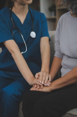 Bayan bakıcı, evinde yaşlı bir kadının düzenli kontrollerini yapıyor..