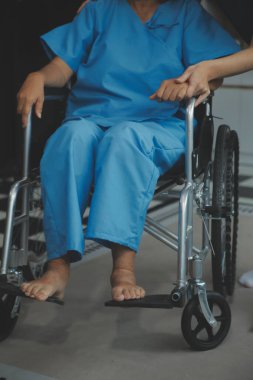 Doktor umut veriyor. Genç kadın hekimin avuçlarında elini tutan yaşlı bayanın gülümsemesini yakından çek. Beyaz önlüklü kadın bakıcı yaşlı insanı cesaretlendiriyor.