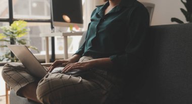Endişeli genç bir kadının dizüstü bilgisayarla koltukta oturup sorunları düşünmesi dikkatimi dağıtıyor. Düşünceli motivasyonsuz kadın pencereye bakıyor, enerji eksikliği hissediyor, evde uzaktan bağımsız işler yapıyor..