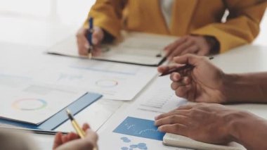 İş adamları beyin fırtınası yapıyor ve finansal veriler ve finansal grafiklerle görüşüyor. Takım çalışması çalışma konsepti.