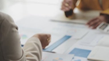 Genç Asyalı iş kadını ofisteki mali verileri analiz ediyor..