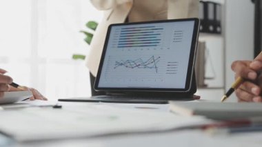 İş kadını ekranda mali grafikle dijital tableti işaret ediyor