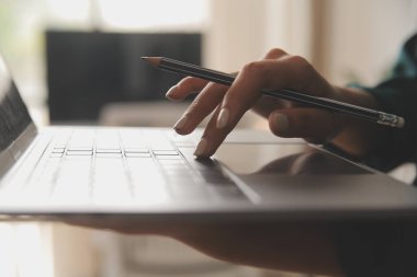 Kadın Yönetici envanteri kontrol etmek için dizüstü bilgisayar kullanıyor. Karton kutularla, e-ticaret çevrimiçi siparişlerle, yiyecek, ilaç ve ürün tedarikleriyle birlikte arka plandaki depo perakende satış merkezinde. Omzunun üstünden.