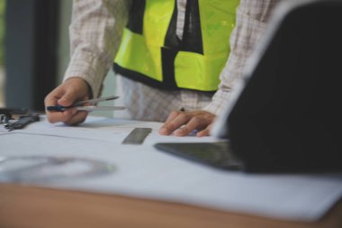 Mühendisler toplantı yapıyor ve ofiste bir planı tartışıyorlar. Mühendislik araçları ve inşaat konsepti