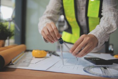 Mühendisler toplantı yapıyor ve ofiste bir planı tartışıyorlar. Mühendislik araçları ve inşaat konsepti