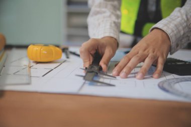 Mühendisler toplantı yapıyor ve ofiste bir planı tartışıyorlar. Mühendislik araçları ve inşaat konsepti