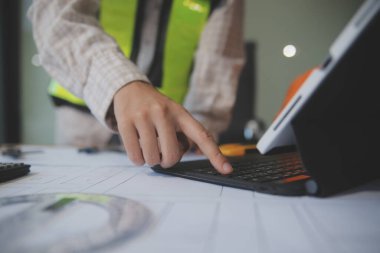 Mühendisler toplantı yapıyor ve ofiste bir planı tartışıyorlar. Mühendislik araçları ve inşaat konsepti